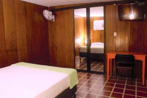 Mały pokój z łóżkiem i biurkiem oraz sypialnią w obiekcie Casa Central completa w mieście Santa Ana