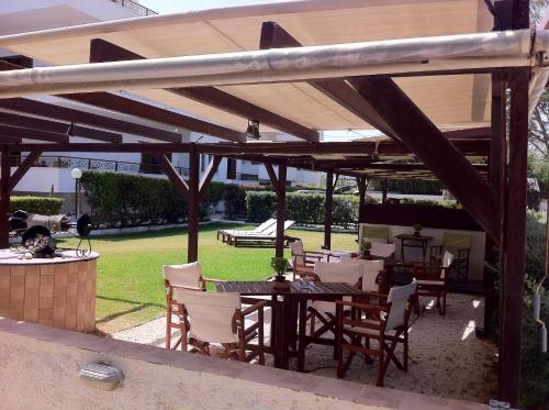 a patio with a table and chairs under a pavilion at Chris Studios & Apartments in Lechaio
