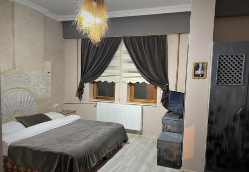 a bedroom with a bed and a large window at tulpar hotel in Urgup