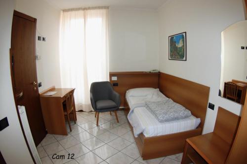 a bedroom with a bed and a desk and a chair at Hotel Fiorentino in Stresa