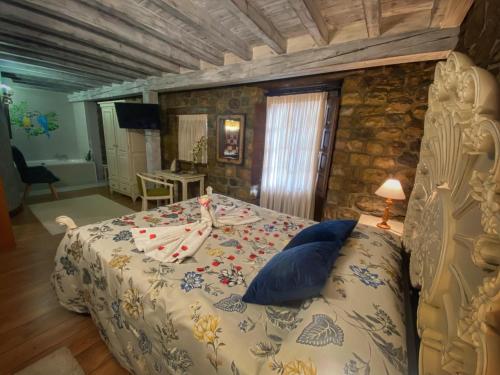 a bedroom with a bed and a stone wall at Hotel Spa Casona La Hondonada in Terán