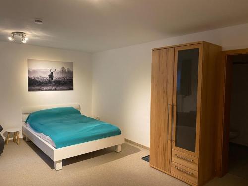 een slaapkamer met een bed en een kast bij Appartement im Herzen des Allgäu‘s in Rettenberg