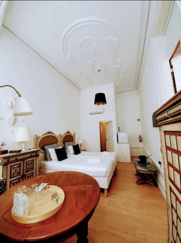 a bedroom with a bed and a table with a sink at Porto Alegria Garden in Porto