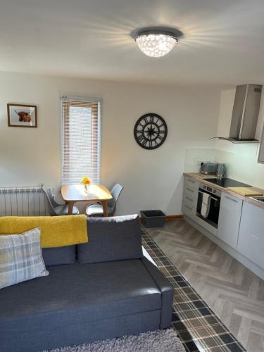 a living room with a couch and a kitchen at Tigh Stobban Apartment 1 in Fort William