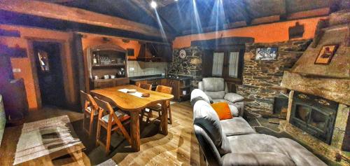 a living room with a table and a stone fireplace at Casa Eladio 