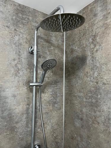 a shower with a shower head in a bathroom at Tigh Stobban Apartment 1 in Fort William