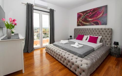 um quarto com uma cama grande e almofadas cor-de-rosa em GKK House private swimming pool luxury house em Skriperón