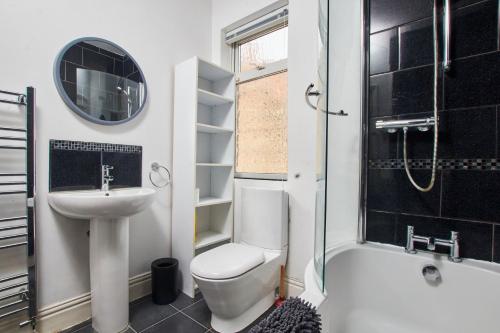 a bathroom with a toilet and a sink and a shower at Stylish 2 Bedroom Flat - Close To Newcastle City Centre in Gateshead