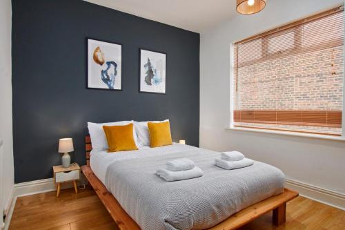 - une chambre avec un grand lit et des oreillers jaunes dans l'établissement Stylish 2 Bedroom Flat - Close To Newcastle City Centre, à Gateshead