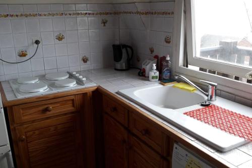 une cuisine avec un évier et une fenêtre dans l'établissement 3 pièces Deauville Centre + wifi, à Deauville