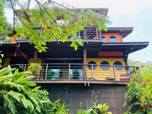 a house with a balcony on the side of it at Flamboyant Residence in Fernando de Noronha