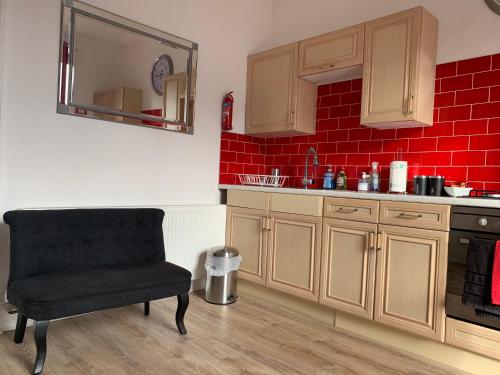 a kitchen with a chair and a red brick wall at Flat G/R 59 Erskine Street Aberdeen in Aberdeen