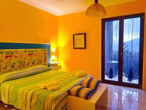 a bedroom with a bed and a large window at B&B Maison Villa Vittorio in Avella