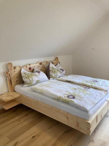 a bedroom with a wooden bed with pillows at Ferienhaus Akogelblick in Landl