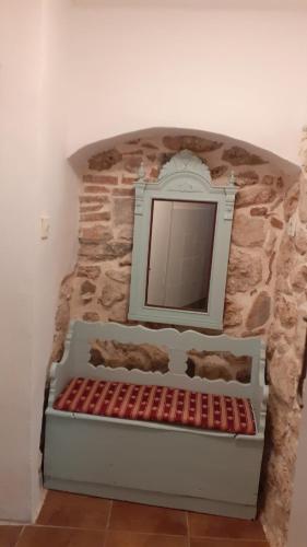 a stone wall with a mirror in a room at Apartman Manuela in Baška