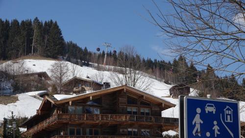 a log cabin in the snow with a sign in front at Design-Appartement Jochberg in Jochberg