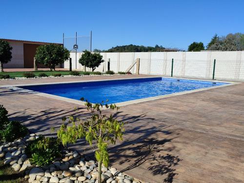 - une piscine dans une cour avec un arbre à côté dans l'établissement Casa acogedora Mar de Albariño con Piscina, à Cambados