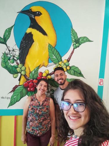 a man and a woman standing in front of a bird at HOSTAL CASA VICTORIA PIJAO in Pijao