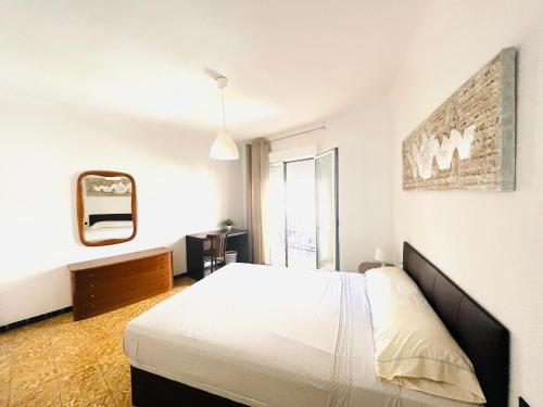 ein weißes Schlafzimmer mit einem Bett und einem Spiegel in der Unterkunft Centro Ciudad apartamento entero in Alicante