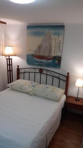 a bedroom with a bed with a painting of a ship at Apartman Manuela in Baška