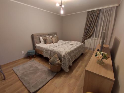 een slaapkamer met een bed, een tafel en een raam bij MAGIC LUX APARTAMENT HUNEDOARA in Hunedoara