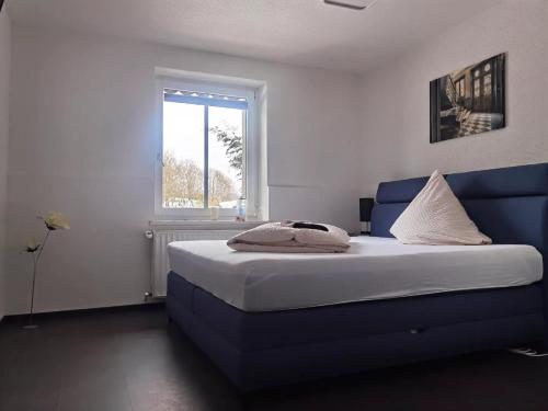a bedroom with a blue bed and a window at Hotel-Restaurant zur Post in Wabern