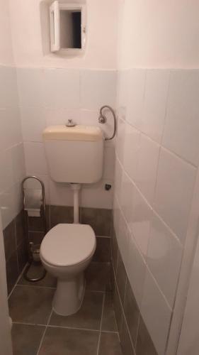 a bathroom with a white toilet and a sink at Apartman Manuela in Baška