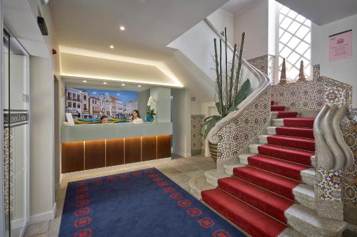 a stairway with a red carpet and a stair case at Welcome In in Aveiro