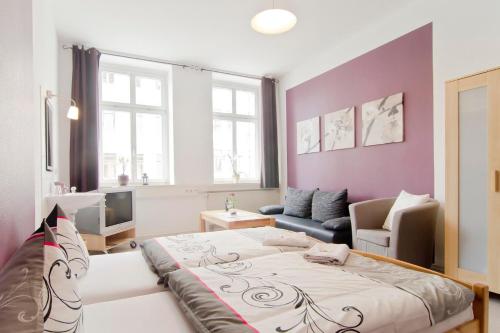 a living room with a large bed and a couch at Pension Piano Forte Leipzig Mitte in Leipzig