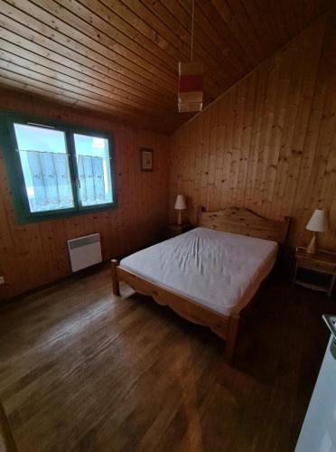 Cette chambre en bois comprend un grand lit. dans l'établissement Le repère du Lynx, à Bellefontaine