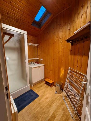 une pièce vide avec une porte coulissante en verre et des murs en bois dans l'établissement Le repère du Lynx, à Bellefontaine