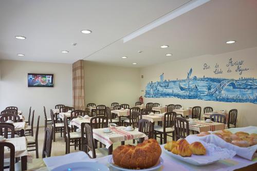 a room filled with tables and chairs with food on them at Welcome In in Aveiro
