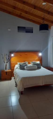 a bedroom with a large bed with a wooden headboard at Eljacaranda_ in Gualeguay