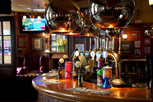 a bar in a pub with a counter with glasses at Tenby House in Tenby