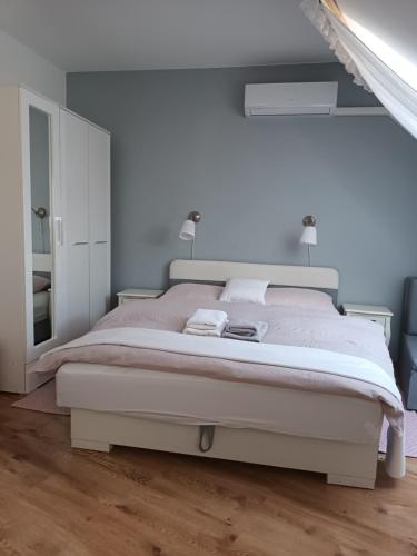 1 dormitorio blanco con 1 cama grande y espejo en Sasvár Apartman, en Eger