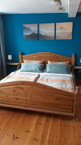 Schlafzimmer mit einem Holzbett mit blauen Wänden in der Unterkunft Fewo Kastel in Nonnweiler