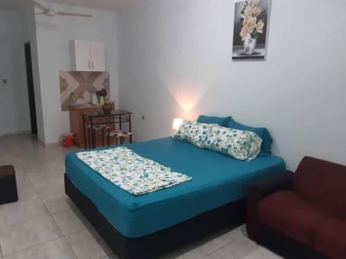a bedroom with a blue bed and a couch at Adorable monoambiente en Asunción in Asunción