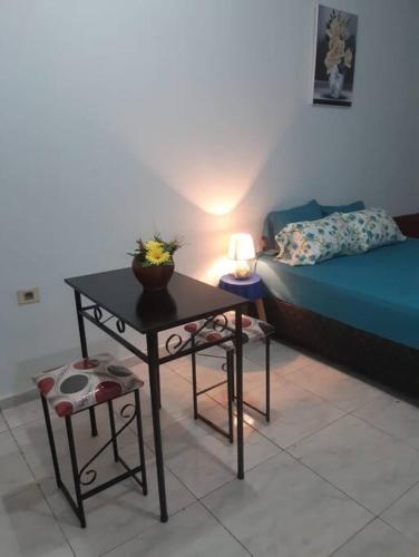 a room with a table and a bed and a lamp at Adorable monoambiente en Asunción in Asuncion