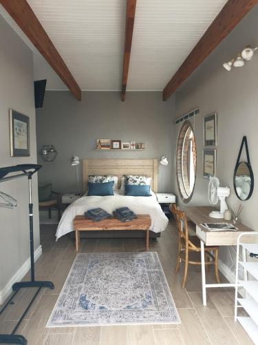 a bedroom with a bed and a table and a desk at Boekenhout Accommodation in Pretoria