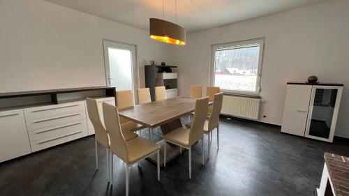 uma cozinha e sala de jantar com uma mesa de madeira e cadeiras em Ferienhaus Traunsteinblick em Nachdemsee