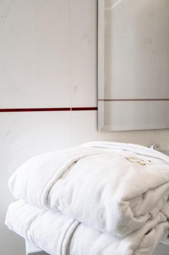 a stack of white towels sitting on a table at Central Park Hotel Modena in Modena