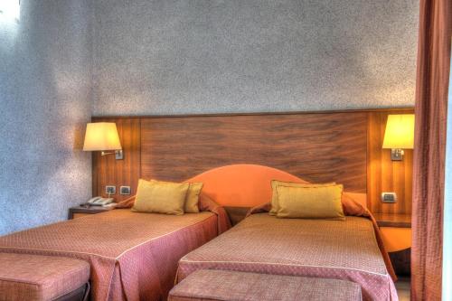 a hotel room with two beds in a room at Central Park Hotel Modena in Modena