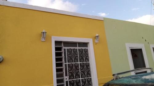 a yellow building with a gate and a door at Casa Colonial Centro in Mérida