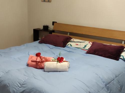 a bed with two roses on top of it at New Home in Ferno
