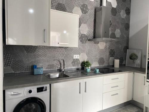 a kitchen with a sink and a washing machine at Loft Manuel de Falla in Maracena