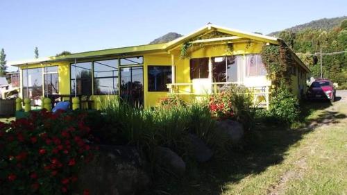 una casa amarilla con muchas ventanas en Hostal y Cabañas Mozart en Puerto Montt