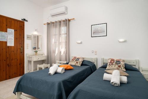 2 camas en una habitación con sábanas azules en Jodi's Pension, en Pitsidia