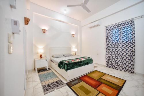 een witte slaapkamer met een bed en een raam bij Luxor Best Way in Luxor