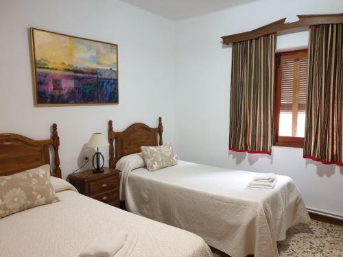 um quarto com 2 camas e uma janela em Casa Rural Sole em Ossa de Montiel