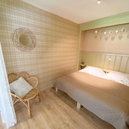 a small bedroom with a bed and a chair at Twisterhof, appartement Anna, in Sustrum